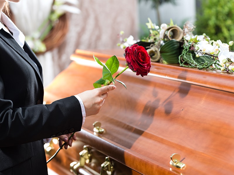 Trauerende Frau am Sarg auf einer Beerdigung in Werl